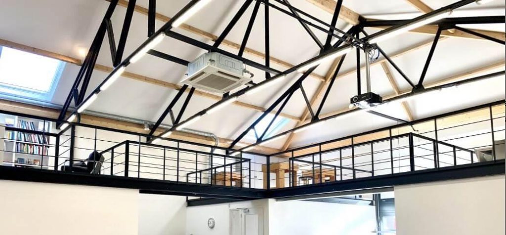 Modern spanplafond in interieur dat de voordelen toont: strak uiterlijk, naadloos design en aanpassingsmogelijkheden met verl