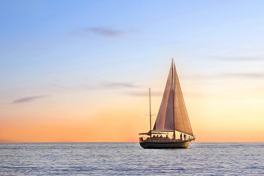 Zeilboot op het water bij Den Helder met uitzicht op de Noordzeekust en duinen